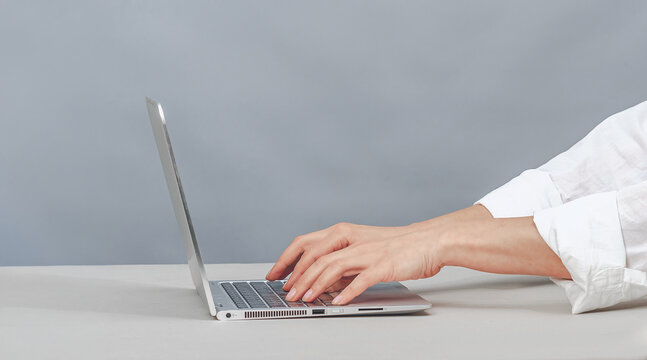 Person typing on a laptop for a virtual medical consultation
